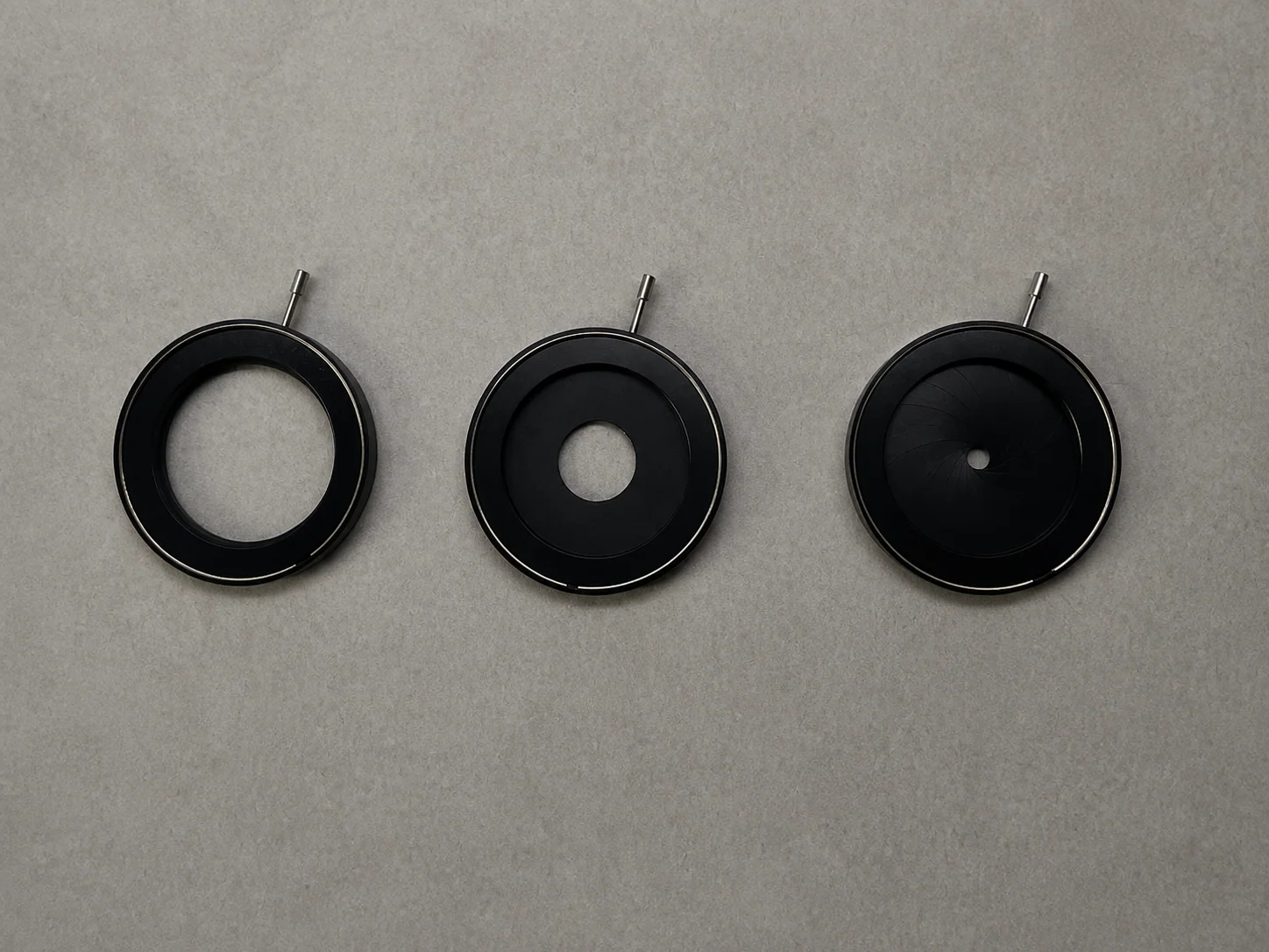 Three iris mechanisms arranged side by side with open, intermediate and nearly closed apertures